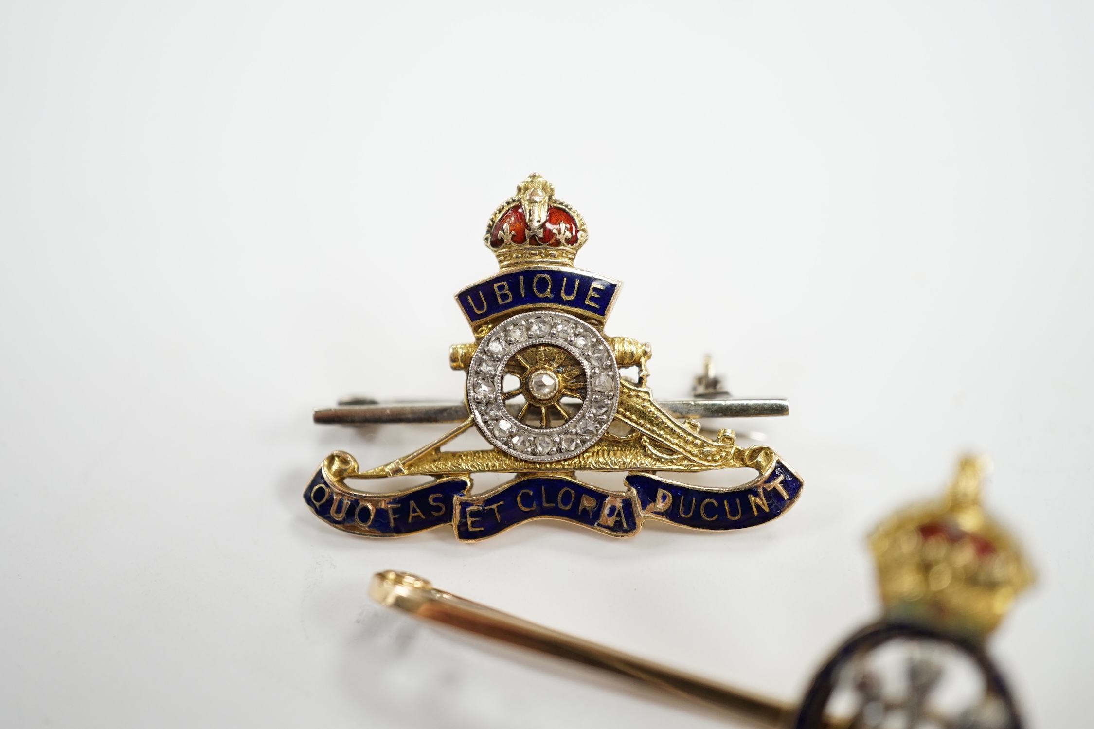 An Edwardian 15ct, enamel and rose cut diamond set Prince of Wales Order of The Garter insignia sweethearts bar brooch, 59mm and a similar yellow metal enamel and diamond chip set Royal Artillery sweethearts brooch, gros